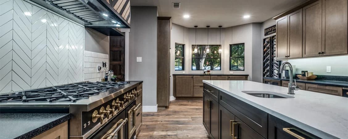 Modern white kitchen with custom wood cabinetry and quartz waterfall island in Denver home